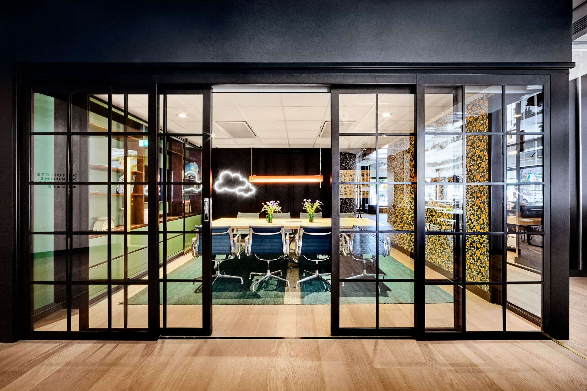 Modern och färgglad konferenslokal med svarta glasdörrar