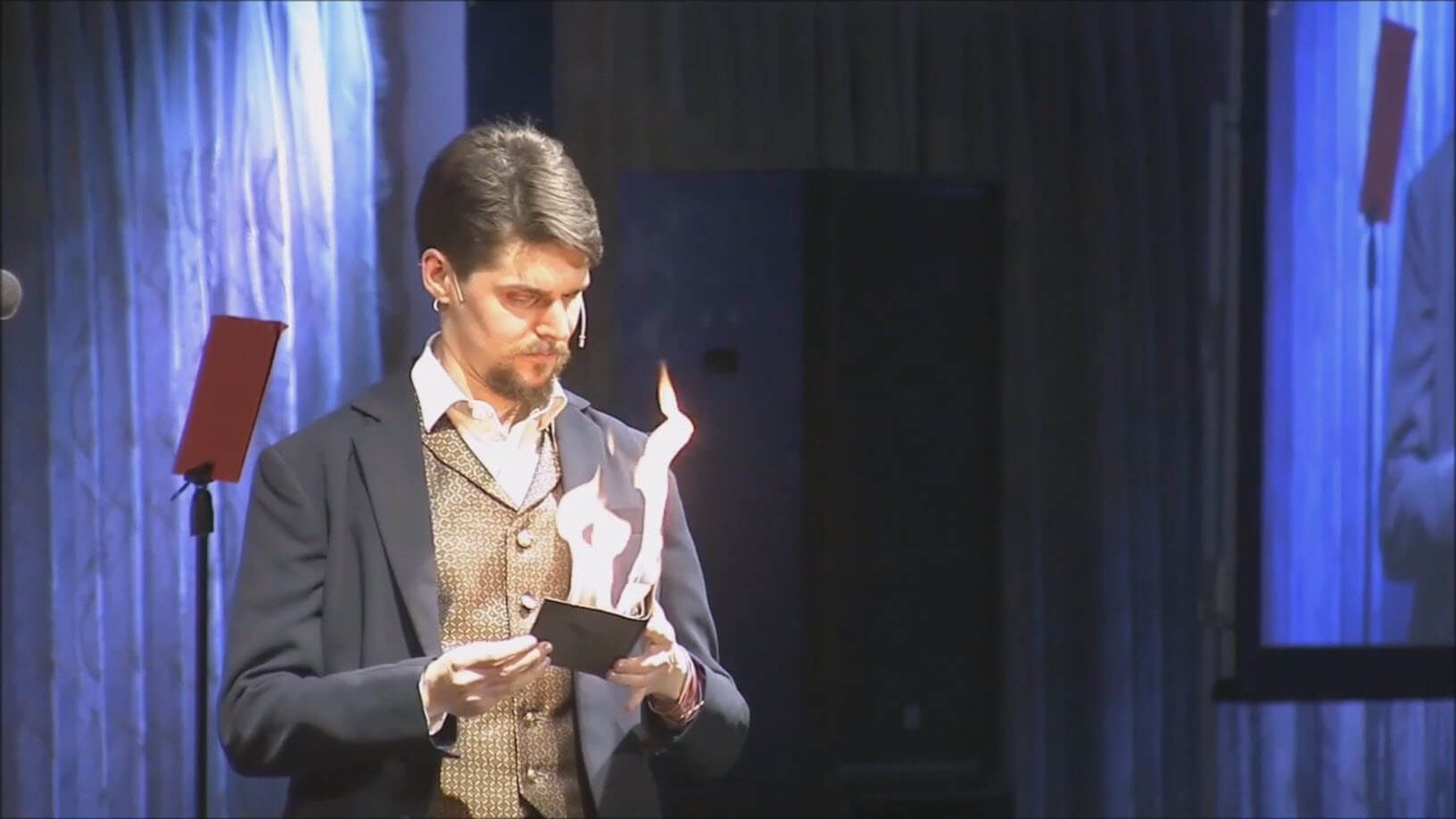 En trollkarl underhåller med en bok som brinner