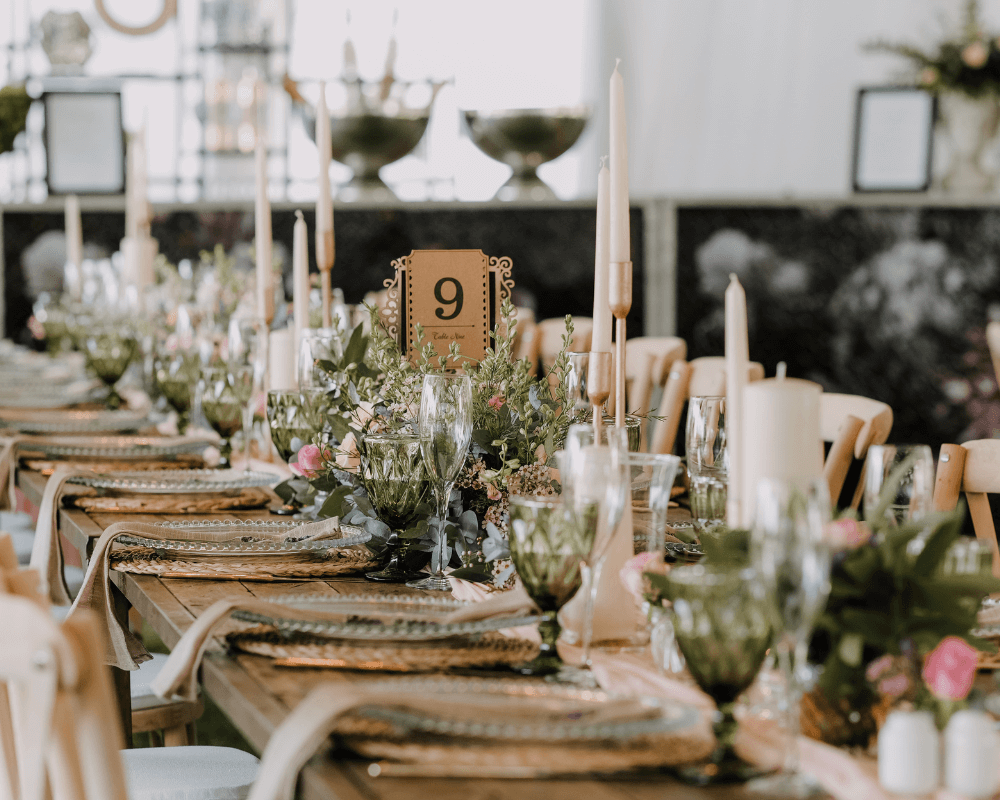 Bord fint dukat till bröllopsmiddagen med ljus, färska blommor och en nummerskylt