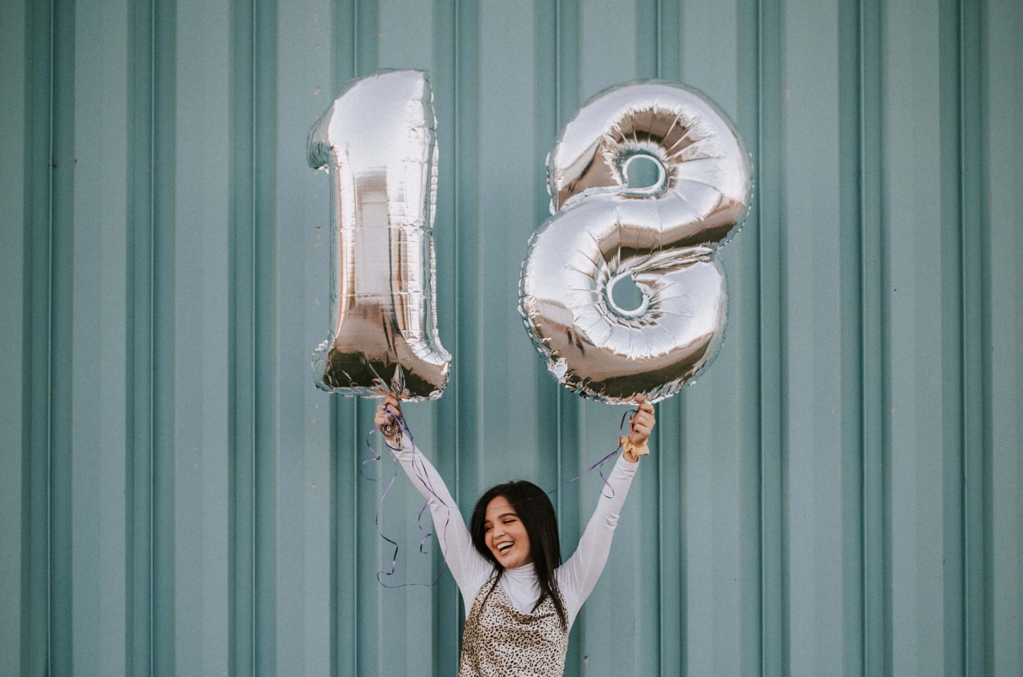 Glad tjej med heliumballonger med siffrorna 1 och 8