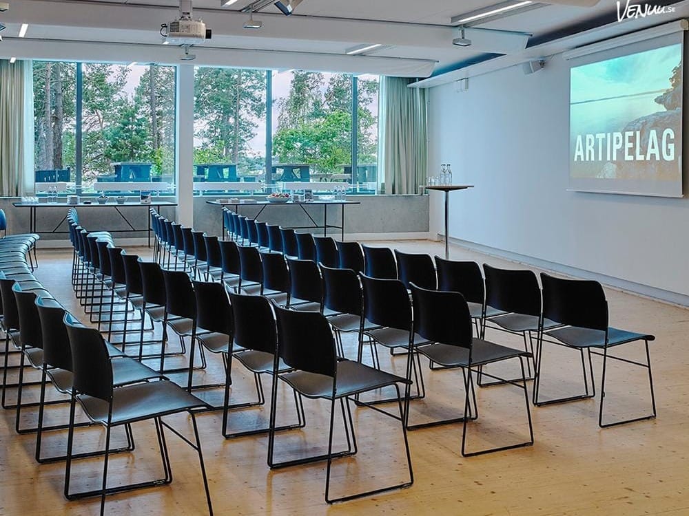 En modern och stilren konferenslokal i skärgården med panoramautsikt över vattnet och toppmodern utrustning.