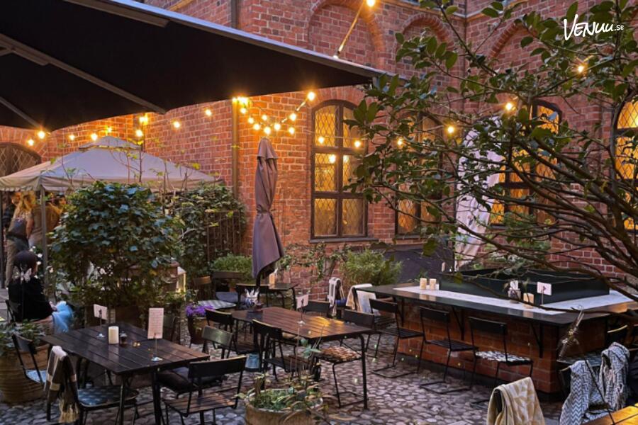 Charmig trädgård vid Årstiderna i Kockska Huset i Malmö, en intim och grönskande plats för sommarens evenemang.