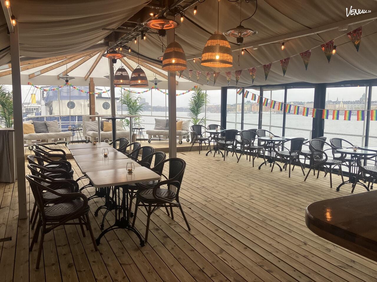 En charmig restaurangbåt med dukade bord och utsikt över Stockholms vatten.