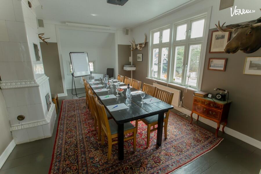 Ett elegant konferensrum i en klassisk herrgårdsmiljö med stilfull inredning.