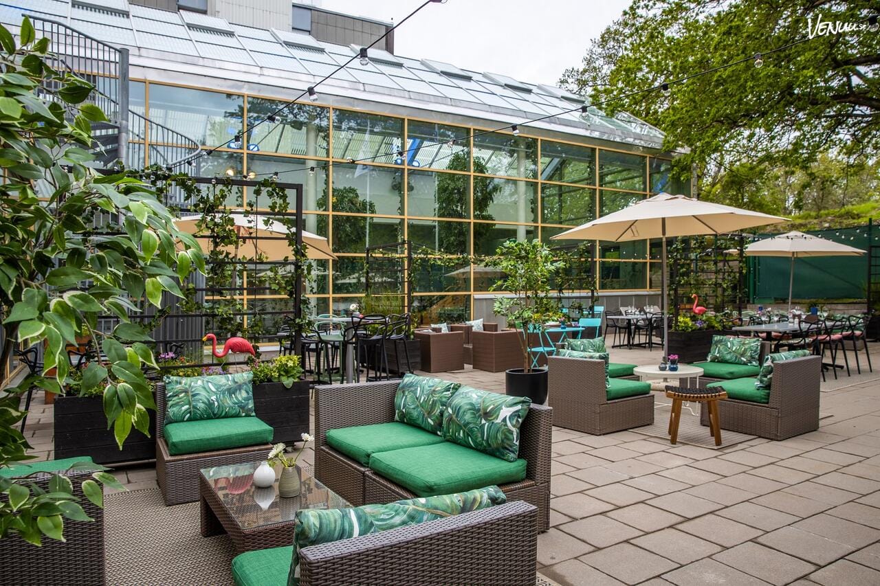 En vacker utomhusmiljö med en stor terrass och panoramautsikt över staden vid solnedgången.