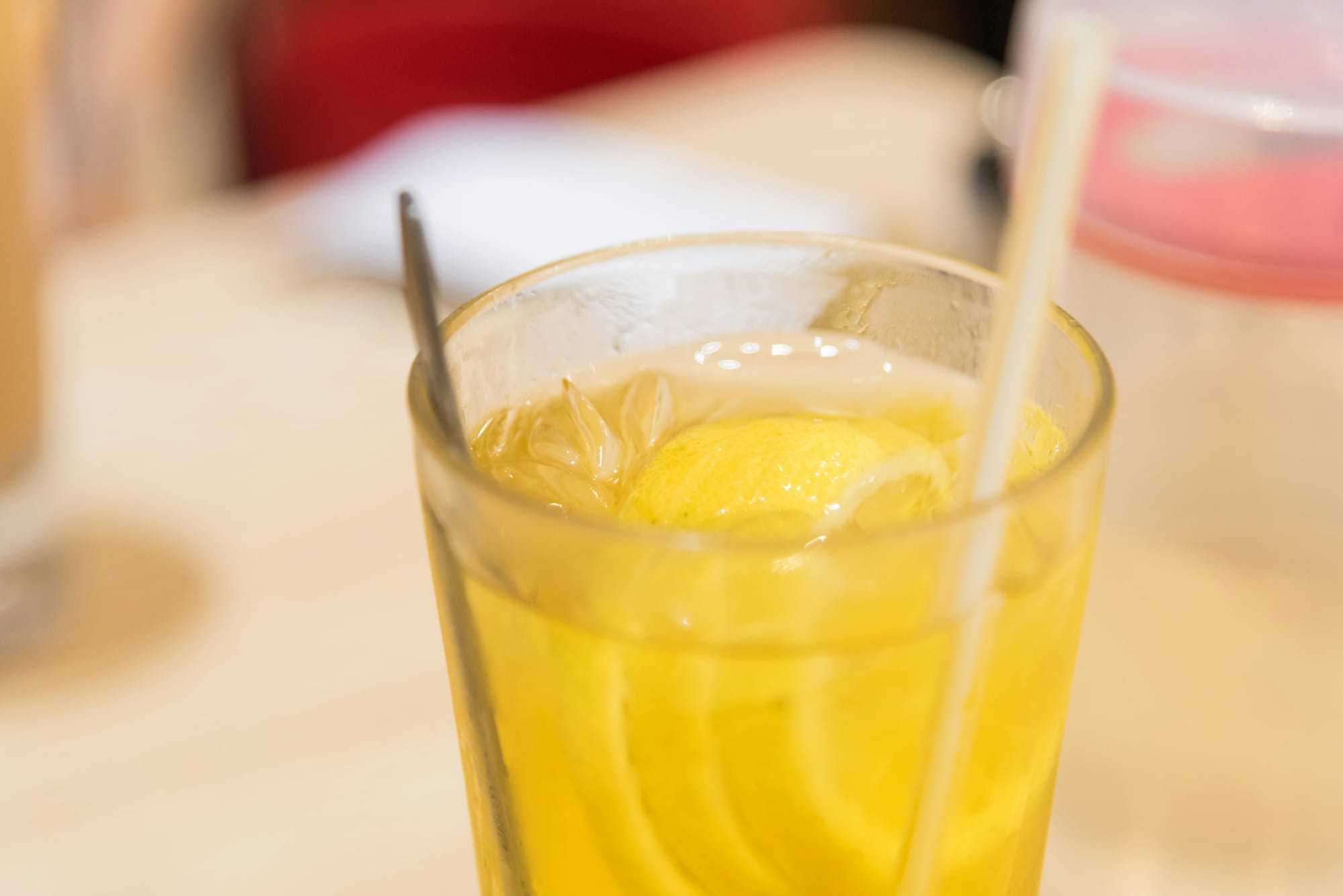 Närbild på ett glas med en Lennart drink, fylld med is, citronskivor och ett sugrör – en somrig och uppfriskande klassiker.