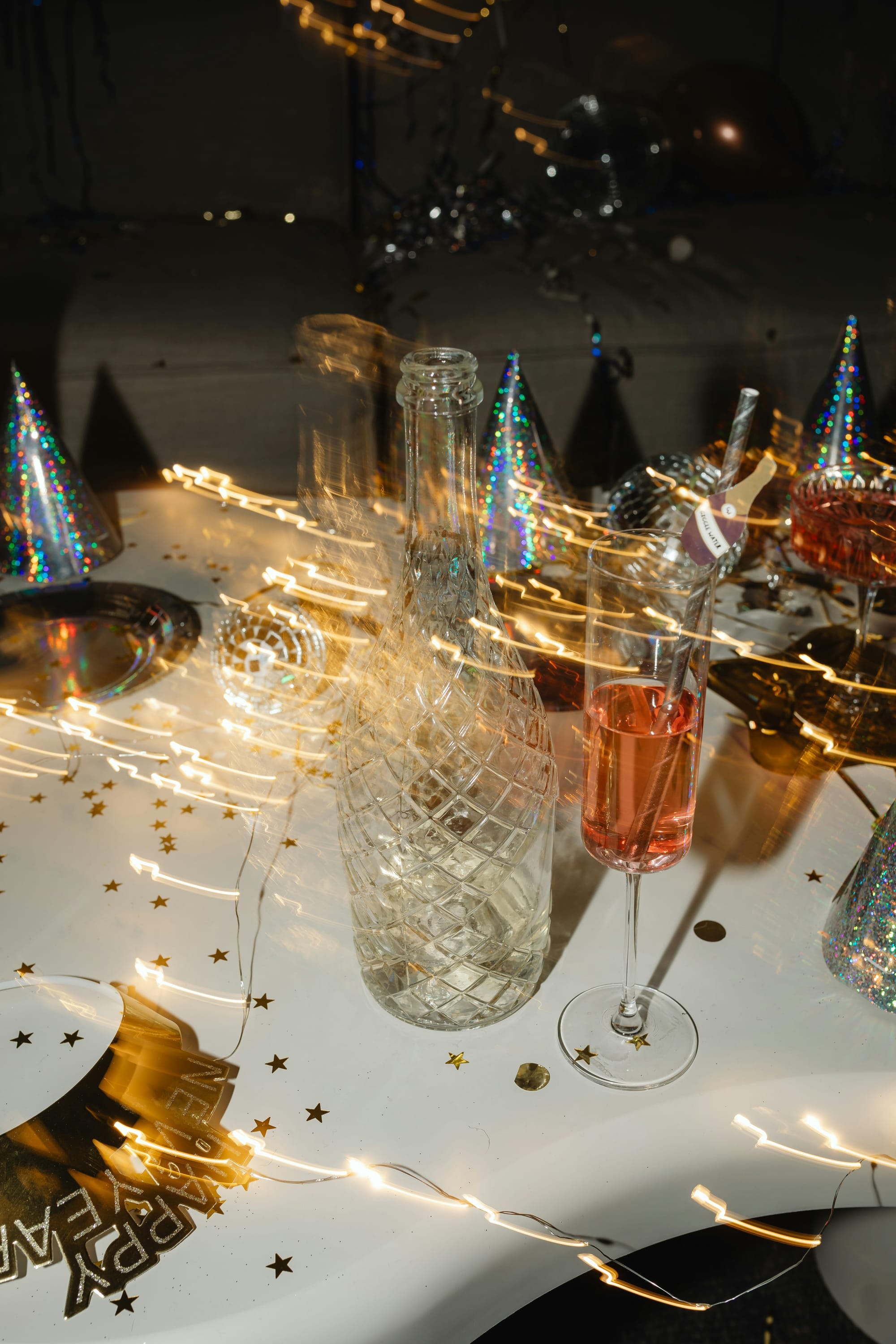 Festligt studentbord med champagneglas, flaskor och glittrande dekorationer â perfekta studentfest tips för en lyckad kvĂ€ll.