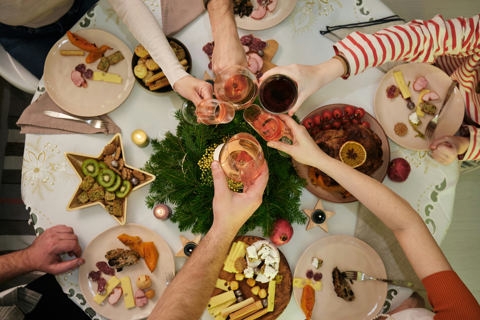 Kollegor som skålar vid ett julbord fyllt med ost, chark och julmat – en typisk företagsjulfest i Sverige 2025